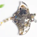 Resin manta ray sculpture filled with natural labradorite crystals on white background - Black Labradorite