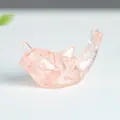 Miniature dolphin resin figurine filled with natural pink crystal stones on desk - Rose Quartz