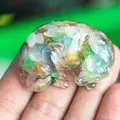 Sleeping Labrador resin figurine with colorful crystal stone inlay held in palm - Colorful Cat Eye