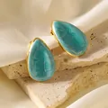Vue détaillée de boucles d'oreilles goutte avec émail bleu ciel sur un socle - Bleu