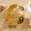 Golden stainless steel starfish and seashell cuff bracelet with pearls on a beach setting - Black
