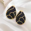 Detailed view of water drop earrings with black enamel and gold plating on silk - Black