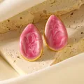 Orecchini a goccia dorati con smalto effetto marmo rosa su un espositore in pietra - Rosa