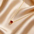 Detailansicht einer roten herzförmigen Edelsteinkette auf elegantem champagnerfarbenem Satin - Dunkelrot