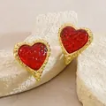 Detalle de pendientes de corazón con textura de martillo dorado y resina roja translúcida - Rojo (FYD6256EH-red)