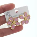 Detailed macro view of pink enamel flower earrings with gold base on stainless steel card - Pink Flower Earrings (FY6198EH)