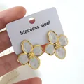 Close-up of white enamel flower earrings with gold edges on a stainless steel card - Flower Earrings (FYD6111)