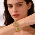Detailed shot of golden sun-shaped bangle with blue enamel on female wrist - Sky Blue