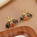 Close-up of 304 stainless steel bee earrings with colorful enamel on a soft background - Black