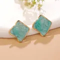 Detail of gold-framed square stud earrings featuring teal marble resin inlay - Blue