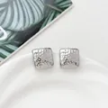 Detailed macro view of square silver steel earrings with hammered texture on white tray - Hammered Square (HQ6023-1)
