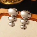 Macro view of silver geometric flower earrings with three stacked oval metal pieces - Modern Art Stack (FYD6088-1)
