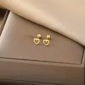 Detailed close-up of golden hollow heart earrings with screw backs on silk fabric - Hollow Heart / Gold