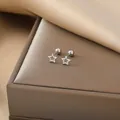 Macro shot of silver hollow star stud earrings with screw back balls on silk - Hollow Star / Steel