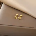 Close-up of golden hollow star stud earrings with ball screw back on silk background - Hollow Star / Gold