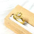 Macro d'une bague fleur dorée réglable avec cristal étincelant dans une boîte à bijoux en bois - Fleur Ajourée avec Zircone (Or)