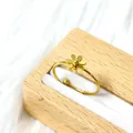Gros plan d'une bague marguerite dorée avec anneau réglable sur velours blanc - Style Petite Marguerite (Or)