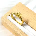 Macro d'une bague marguerite dorée sur un support de bijoux blanc avec détails en bois - Style Grosse Marguerite (Or)