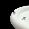 Vue macro de boucles d'oreilles minimalistes argentées serties de zircons à quatre griffes - Taille 2 / Acier