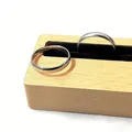 Set de anillos lisos minimalistas color plata en un expositor de madera y terciopelo negro - Estilo de Banda Simple