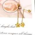 Detail of gold flower drop earrings with chain tassels on a stylish magazine background - Gold 3D Flower Tassel