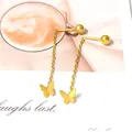 Detalle de pendientes borla mariposa dorados con tachuelas esféricas en fondo artístico - Dorado-Mariposa Borla
