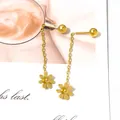 Detail van gouden bloemen kwastjes oorbellen met madeliefjes op een tijdschrift - Goudkleurige Kleine Madeliefje Lange Oorketting Stijl