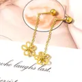 Detailopname van gouden bloem oorbellen met lange kettingen op een witte kaart - Goudkleurige Holle Vijfbladige Bloem Lange Oorketting Stijl