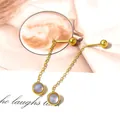 Detail of elegant gold chain earrings featuring iridescent stones and a minimalist design - Moonstone Tassel / Gold