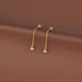 Macro shot of gold tassel drop earrings with small beads and delicate chains on brown backdrop - Round Ball Tassel (Pair) / Gold