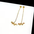 Detail of gold snake earrings featuring delicate chains and textured serpent pendants - Snake Ear Thread / Gold