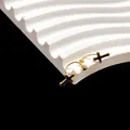 Detalle de pendientes dorados en forma de U con dijes de cruz en esmalte negro - Cruz Fina Dorada
