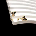 Detalle de pendientes en U dorados con mariposa de esmalte negro y cierre de bola - Mariposa dorada