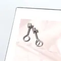 Detalle macro de pendientes geométricos de acero de titanio con cubo pulido y diseño de lazo - Estilo Cuadrado en Forma de 9 Pequeño / Plateado