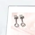 Pendientes de botón cuadrados minimalistas de acero de titanio sobre fondo rosa claro - Estilo Cuadrado en Forma de 9 Pequeño / Plateado