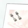 Macro-opname van gepolijste geometrische kubus oorknopjes met een schroefsluiting - Dubbele Vierkante Tragus Knop / Zilver