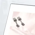 Detail van zilveren titanium stalen oorbellen met een geometrisch kubus- en bolontwerp - Vierkante Draai Bal Stijl / Zilver