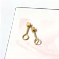 Detail van minimalistische vergulde titanium stalen oorbellen met kleine geometrische kubussen - Kleine 9-Vorm Vierkante Stijl / Goud