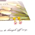 Vue détaillée des boucles d'oreilles étoile rose et dorée sur carte décorative - 5mm Or Rose Zircone Étoile Dos Plat Vissé