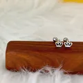 Vue macro de la boucle d'oreille couronne à vis en acier argenté et émail noir - Couronne / Acier