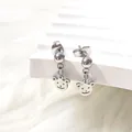 Detail of silver titanium steel bear stud earrings on a white plush background - Bear
