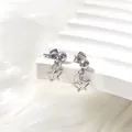 Close-up of silver steel butterfly dangle earrings on a soft white decorative stand - Butterfly