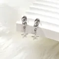 Detailed close-up of silver hollow star drop earrings on a minimalist white background - Small Hollow Star