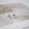Détails macro de boucles d'oreilles géométriques argentées avec fermoirs à vis sécurisés - Style Perle Cercle Argenté