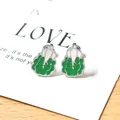 Detalle de pendientes de col creativos con esmalte verde y blanco sobre metal plateado - Green Cabbage