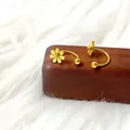 Detail van gouden madeliefje oorbellen met schroefsluiting op een houten displayhouder - Goudkleurige Kleine Madeliefje U-Vorm Stijl