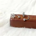 Macro-opname van zilveren titanium stalen klaver oorbellen met fijne bloemendetails - Zilverkleurige Holle Vijfbladige Bloem U-Vorm Stijl