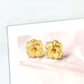Primer plano detallado de los pendientes de margarita dorada con pétalos de doble capa - Estilo de Flor Hueca de Doble Capa Tono Dorado