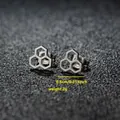 Gros plan sur des boucles d'oreilles alvéolées en acier inoxydable avec détails de taille - Hexagone Géométrique