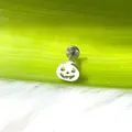 Primer plano detallado de un piercing de acero titanio con forma de calabaza en verde - Calabaza